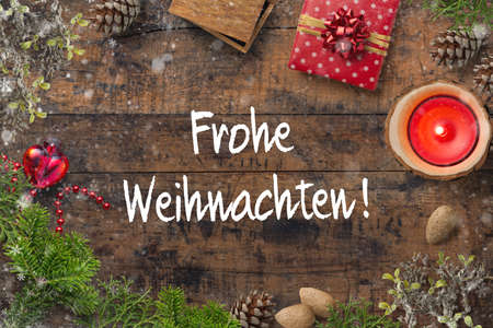 Christmas decoration on rustic wooden background and the German message for "Merry Christmas!"の写真素材