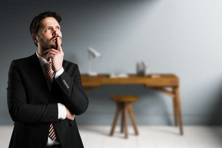 businessman is thinking intensely in front of an office sceneの写真素材