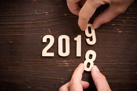 hand changing a wooden number,  symbolizng the change from 2018 to 2019の写真素材