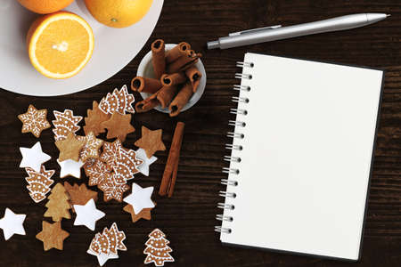 christmas decoration on rustic wooden background and an empty note pad with a penの写真素材