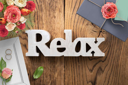 Frame with two wedding rings and the word RELAX on wooden backgroundの写真素材
