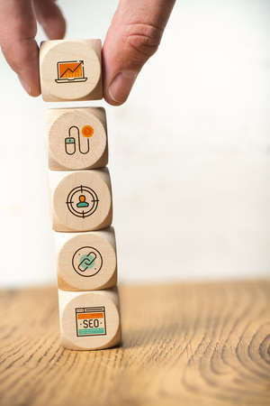 SEO strategy with components for successful marketing as icons on cubes on wooden background