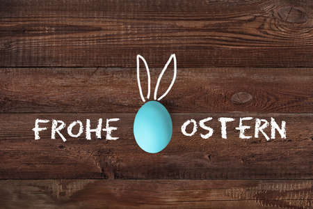 Easter Eggs on wooden background with message "Happy Easter" in Germanの写真素材