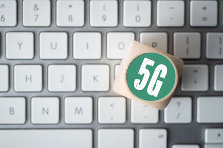 Technology name 5G on a cube on a computer keyboardの写真素材