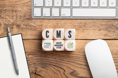acronym CMS on cubes in front of a computer keyboardの写真素材