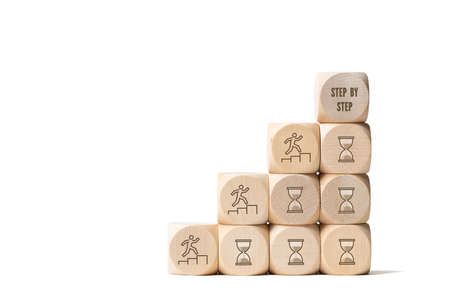 a stair symbolized by cubes and the slogan: step by step isolated on whiteの写真素材