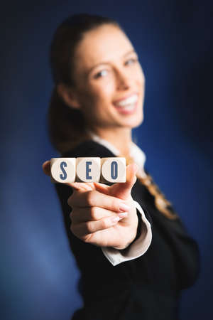 woman holding cubes with the acronym SEO for search engine optimizationの写真素材
