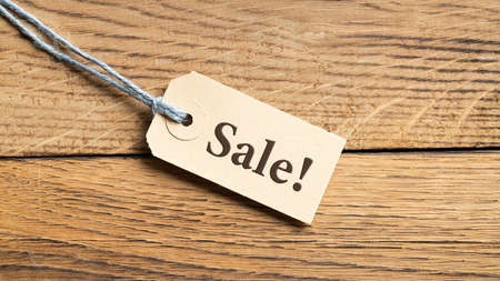 Hangtag with title "Sale!" on wooden backgroundの写真素材