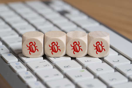 cubes with bug symbols, standing for software errors on a keyboardの写真素材