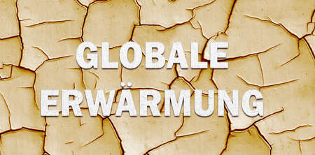Climate change banner with "GLOABL WARMING" lettering in German over dry cracked mudの写真素材