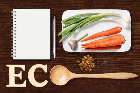 Overhead view of carved letters spelling ECO surrounded by assorted vegetablesの写真素材