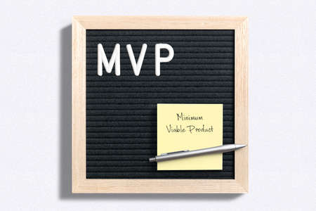 MVP written on letter board next to sticky note with Minimum Viable Product written on it over plain white surfaceの写真素材