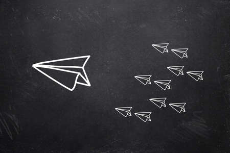 leading plane with many followers drawn on a blackboardの写真素材