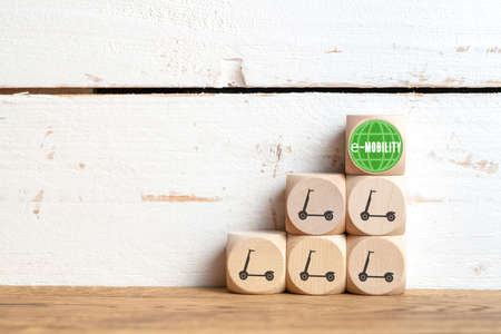 cubes with electric kick scooter symbols on wooden background