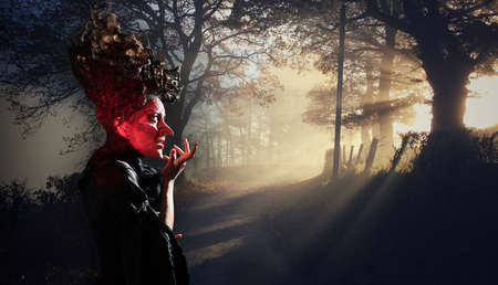 scary witch summoning a spell in a dark forest