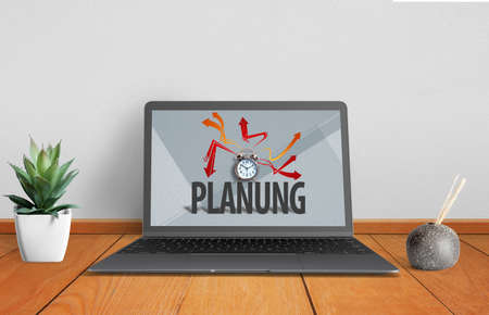 Laptop with image of alarm clock on paper background with the German word for "planning" on wooden surfaceの写真素材