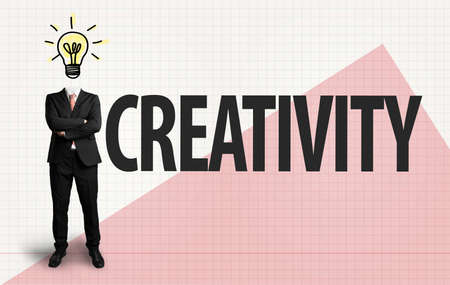 businessman with lightbulb as a head and the word "creativity" on paper backgroundの写真素材