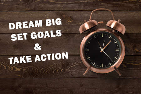 alarm clock with motivational message on wooden backgroundの写真素材