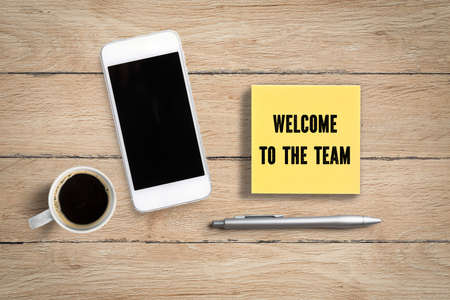 notepad with message "welcome to the team" on wooden backgroundの写真素材