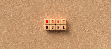 cubes with the words DON'T and DONE on cork background - 3D rendered illustrationの写真素材