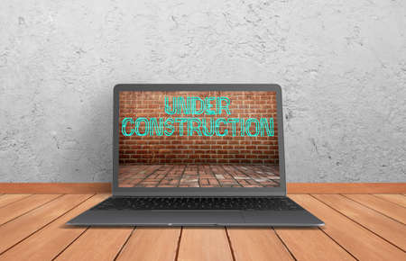 notebook with a picture of a wall with message under construction on wooden ground