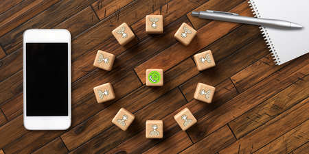 cubes with icons symbolizing a call center surrounded by a smartphone and a notepadの写真素材