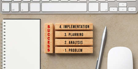 blocks with message PROBLEM, ANALYSIS, PLANNING, IMPLEMENTATION and SUCCESS on paper background