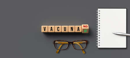 cubes with Spanish message VACCINATE and options YES or NO on gray pavementの写真素材