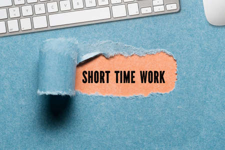 torn paper revealing a document with the text SHORT TIME WORKの写真素材