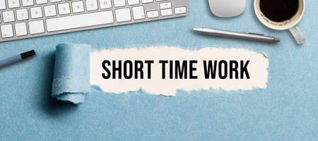 torn paper revealing a document with the text SHORT TIME WORK