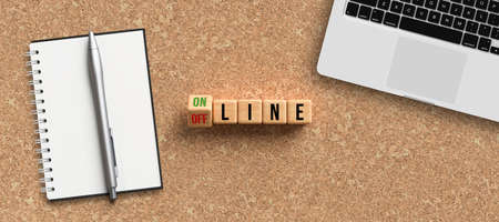 cubes with message ONLINE and OFFLINE surrounded by office items on cork backgroundの写真素材