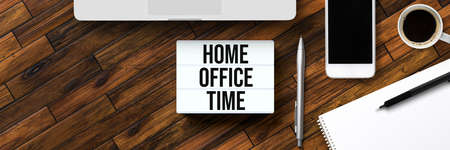 lightbox with message HOME OFFICE TIME surrounded by office items on wooden backgroundの写真素材