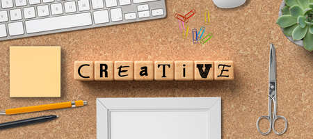 cubes with the word CREATIVITY and office items on cork backgroundの写真素材