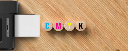 message CMYK and a printer on wooden background
