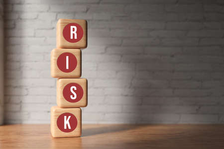 wooden cubes with the word RISK in front of a brick wall - 3d illustrationの写真素材