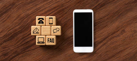 cubes with contact options and smartphone on wooden background
