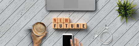 hand is typing on a laptop and cubes with message NEW FUTURE on wooden backgroundの写真素材