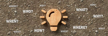 wooden lightbulb on dirt gravel background with the words WHEN, WHAT, WHERE, WHO, WHY and HOW - 3d...