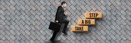 businessman and cubes with message TAKE A BIG STEP on stone pavement background