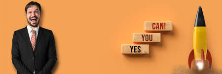 happy businessman and cubes with message OH YES, YOU CAN on orange backgroundの写真素材