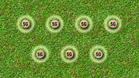 cylinders with message 5G ordered in a grid on grass background - 3d illustrationの写真素材