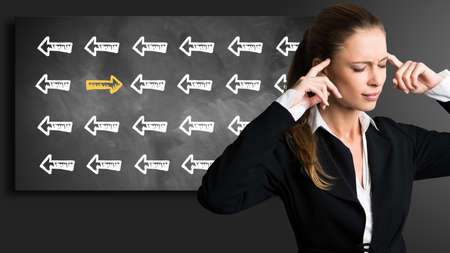 businesswoman standing in front of a chalkboard thinking about a solution to a problemの写真素材