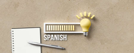 lightbulb and loading bar with the word SPANISH with notepad and pen on paper backgroundの写真素材