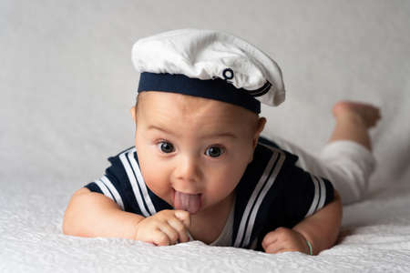 cute little baby boy in sailor uniform on a bed