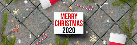 lightbox with message MERRY CHRISTMAS 2020 and christmas decoration on stone pavement backgroundの写真素材