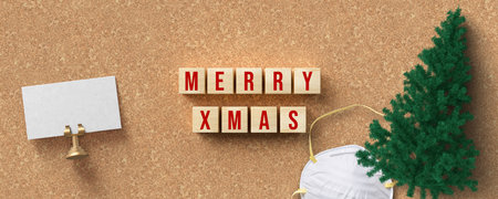 cubes with message MERRY XMAS and christmas decoration on cork backgroundの写真素材