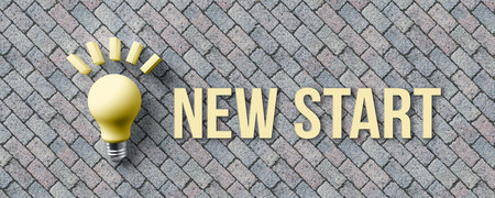 message NEW START and a lightbulb symbol on stone pavement background - 3d illustrationの写真素材
