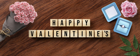 cubes with message HAPPY VALENTINE'S and romantic decoration on wooden backgroundの写真素材