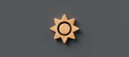 Shining wooden sun symbol on a grey panorama background centered with copyspace conceptual of the...