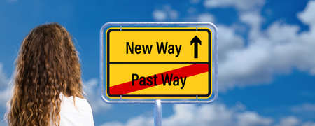 businesswoman looking at signpost with the words PAST WAY and NEW WAY in front of a cloudy sky